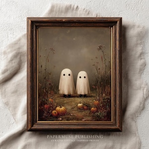 May include: A framed vintage-style print featuring two friendly ghost figures standing in a field with pumpkins. The artwork has a dark brown wooden frame and a muted color palette, evoking a Halloween or autumn theme.