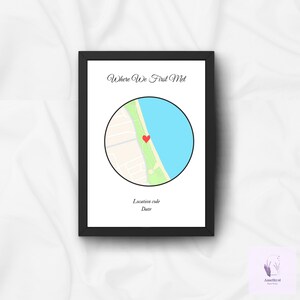 May include: A black framed print featuring the text "Where We First Met" above a circular map illustration. The map depicts a coastal area with a red heart marking a location. Below the map are lines for a location code and date.