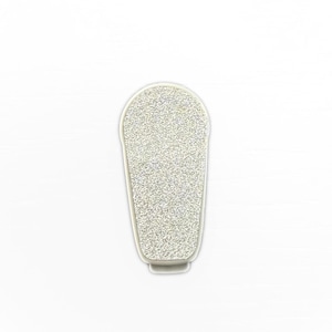 Op de afbeelding: Een zilveren glitter nagelvijl met een afgeronde bovenkant en een rechthoekig lichaam. De nagelvijl heeft een witte rand en een getextureerd oppervlak, ontworpen voor het gladmaken en vormen van nagels. De vijl wordt getoond tegen een witte achtergrond.