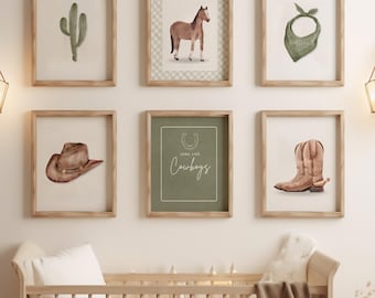 May include: A nursery scene featuring a light wood crib, a round rug, and framed watercolor art prints. The prints depict a cactus, horse, bandana, cowboy hat, cowboy boots, and the text "Cowboys". Decorative wall sconces and a woven side table complete the room.