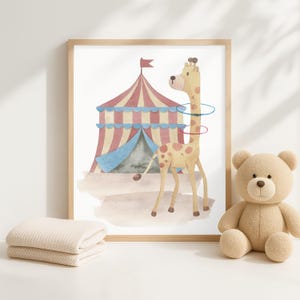 Pode incluir: Impress&atilde;o em aquarela emoldurada de uma girafa com um fundo de tenda de circo. A girafa tem manchas marrons e usa bambol&ecirc;s. A tenda &eacute; vermelha e azul. Um urso de pel&uacute;cia bege e um cobertor dobrado est&atilde;o em primeiro plano.