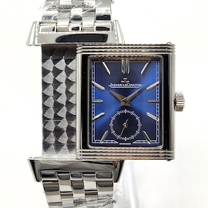 May include: A silver-toned wristwatch with a square blue face and a small seconds dial. The watch features the Jaeger-LeCoultre logo and a silver link band. The watch face is approximately 1 inch wide.