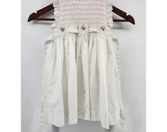 Abito da bambina senza maniche in cotone bianco con ricami floreali e volant, lavorato a mano.