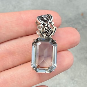 Op de afbeelding: Een witte keramische mok met een zwarte handgreep en de tekst "But First, Coffee" in een vetgedrukte, zwarte letter. De mok staat tegen een vage achtergrond, wat een gezellige setting suggereert.