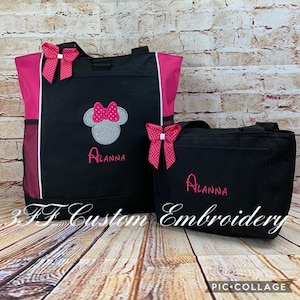 May include: Two black tote bags with pink accents. The larger bag has a pink and white polka dot bow and a silver Minnie Mouse head with a pink bow. The smaller bag has a pink and white polka dot bow. Both bags are personalized with the name "Alanna".