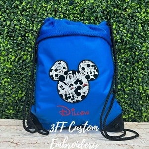 May include: A blue drawstring bag with a black and white Mickey Mouse head design and the name "Dillon" embroidered in red. The bag also has the text "3FF Custom Embroidery" printed on it.