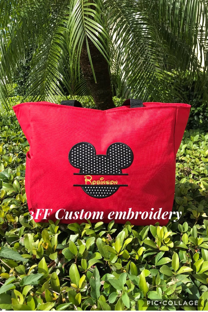 Peut inclure: Sac fourre-tout en toile rouge avec des oreilles de Mickey Mouse &agrave; pois noirs et blancs et le nom "Robinson" brod&eacute; en jaune. Le sac a des anses noires et le texte "3FF Custom embroidery" est imprim&eacute; en bas.
