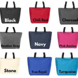 May include: Nine tote bags in different colors, including black, chili red, charcoal, heather grey, navy, pink azalea, stone, true royal, and turquoise. Each bag has a zipper closure and two handles.