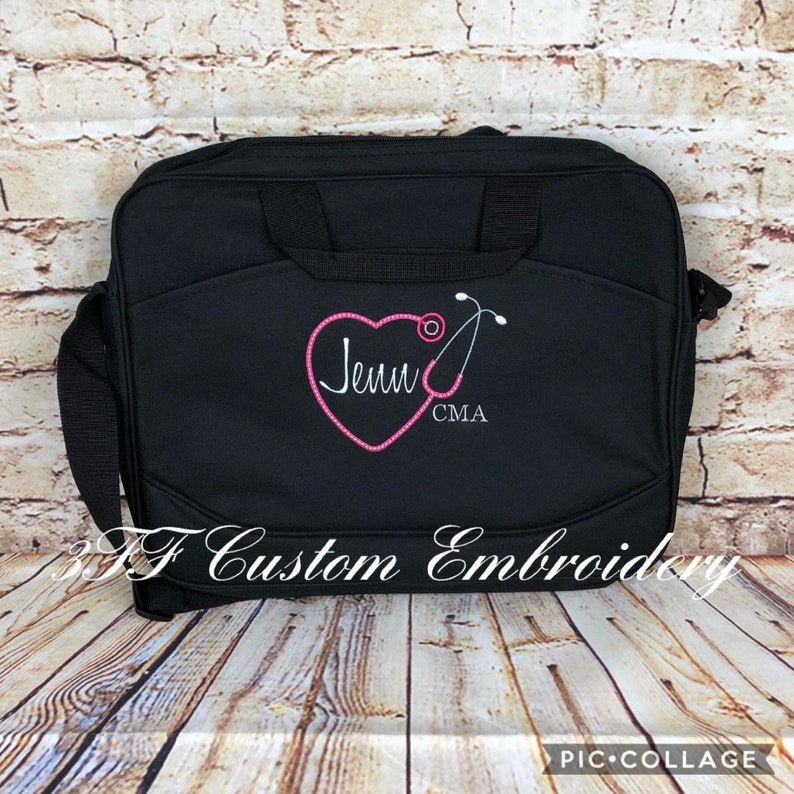 May include: Black laptop bag with a pink heart and a stethoscope embroidered on it. The heart has the name "Jenn" and the letters "CMA" embroidered inside it.