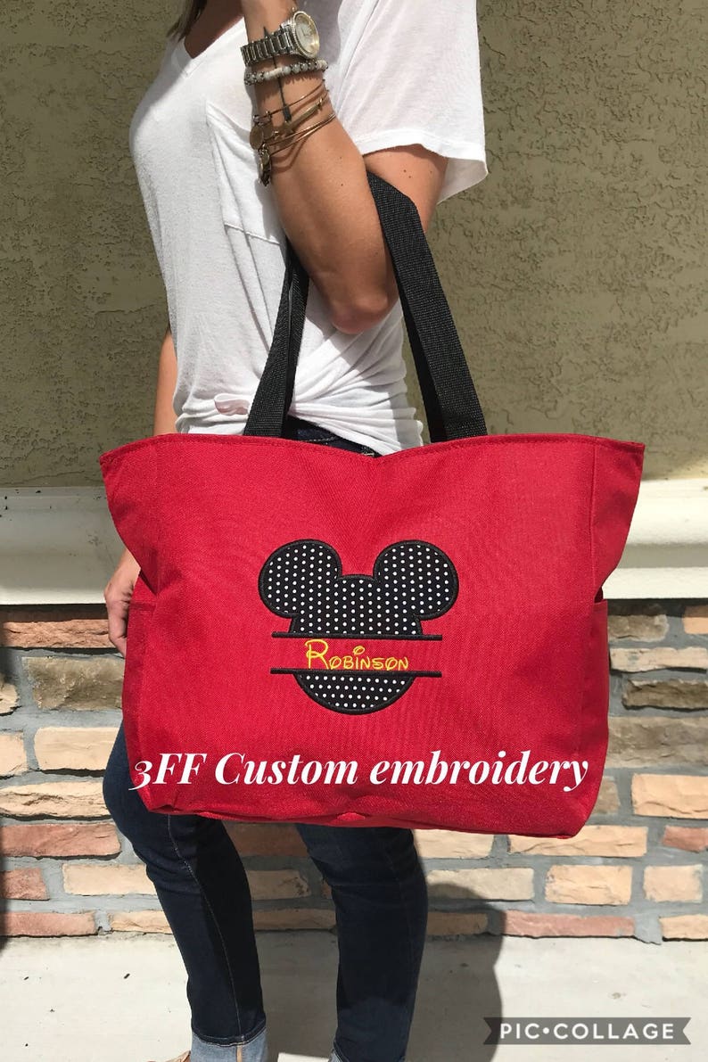 Peut inclure: Sac fourre-tout en toile rouge avec des anses noires et une t&ecirc;te de Mickey Mouse noire et blanche avec le nom "Robinson" brod&eacute; en jaune. Le sac porte l'inscription "3FF Custom embroidery" imprim&eacute;e sur le devant.