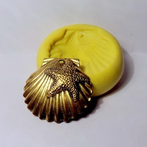 May include: A gold-colored seashell pendant with a starfish design. The pendant is shown next to a yellow silicone mold.
