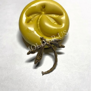 May include: A yellow silicone mold with a dragonfly design. The mold is used to create resin jewelry or other crafts.