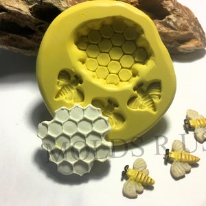 Puede incluir: Molde de silicona amarillo con tres diseños de abejas y panales. El molde se muestra con tres piezas de resina terminadas: un panal y dos abejas.