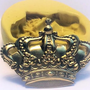 Pode incluir: Um molde de coroa dourado com detalhes intrincados, incluindo um topo pontiagudo e uma borda de contas. O molde é feito de silicone e é projetado para criar decorações de bolo ou outras artesanato comestíveis.
