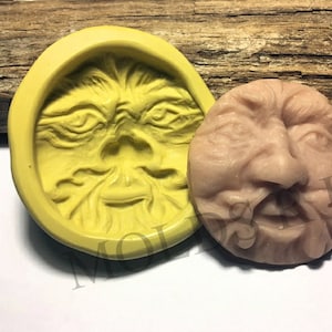 Peut inclure: Deux moules en silicone pour la fabrication d'objets en résine. Un moule est jaune et présente un visage détaillé avec une barbe. L'autre moule est de couleur chair et présente un visage détaillé avec une moustache et une barbe.