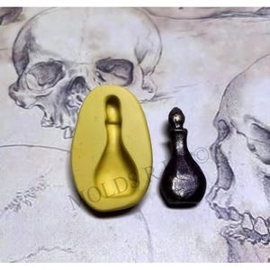 May include: A silicone mould for making a small glass bottle with a stopper. The mould is yellow and the bottle is shown in the image as a dark brown glass bottle.