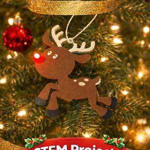 Puede incluir: Adorno navideño de reno de madera con nariz roja y manchas blancas, colgado de un árbol de Navidad. El texto "LED Reindeer" está en la parte superior y "STEM Project" en la inferior.