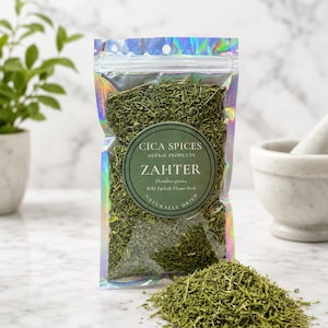 Könnte beinhalten: Ein durchsichtiger, irisierender holografischer Beutel gefüllt mit getrockneten grünen Zahter-Kräutern. Das runde Etikett trägt die Aufschrift CICA SPICES HERBAL PRODUCTS ZAHTER Thymbra spicata Wild Turkish Thyme Herb NATURALLY DRIED.