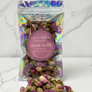 Könnte beinhalten: Ein holografischer, wiederverschließbarer Beutel gefüllt mit getrockneten rosa Rosenknospen. Ein rundes Etikett auf der Vorderseite trägt die Aufschrift CICA SPICES HERBAL PRODUCTS ROSE BUDS Rosa damascena Floral Tea & Botanical Crafts NATURALLY DRIED.