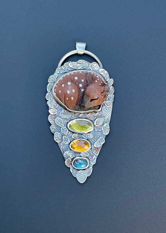 Sleeping fawn on bed of leaves with gemstones
