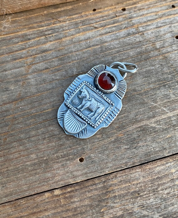 Sacred cow and garnet pendant