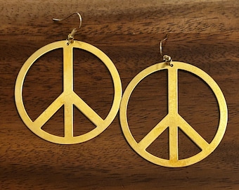 Brincos vintage dourados com símbolo da paz: joias leves e marcantes