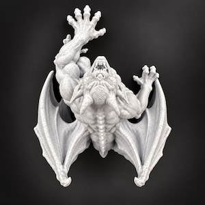 May include: A light gray, speckled gargoyle figurine with a muscular build, pointed ears, and horns. The creature is depicted in a climbing pose with one arm extended upward, wings spread wide, and its mouth open to reveal sharp teeth and fangs.