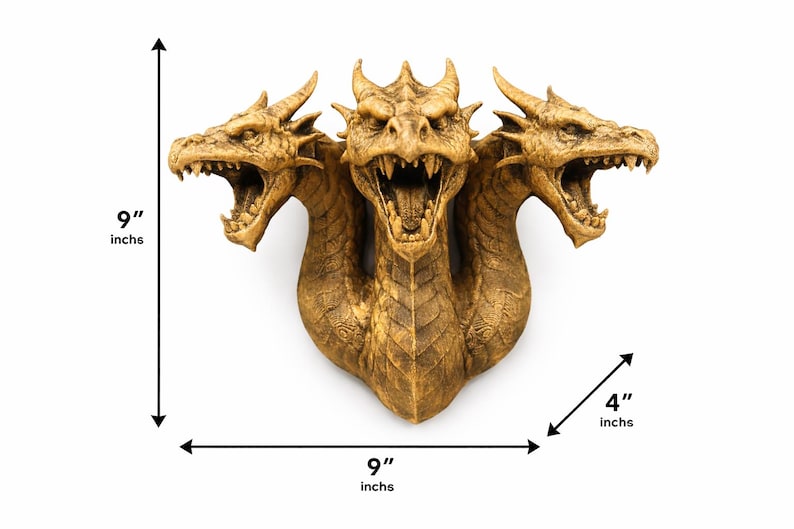 May include: A detailed, golden-colored three-headed dragon sculpture. The sculpture is 9 inches tall and 9 inches wide, with a depth of 4 inches. The dragon has an open mouth with visible teeth and is mounted on a white background.