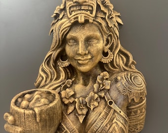 May include: A golden-colored wall sculpture of a woman with long wavy hair, floral accents, and a tiki mask headdress. She holds a bowl in her hands. The sculpture has detailed carvings and a textured finish.