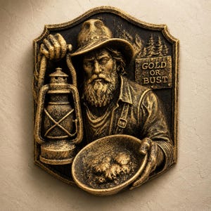 Peut inclure: Plaque murale détaillée représentant un chercheur d'or tenant une lanterne et une poêle remplie d'or. Le prospecteur porte un chapeau et a une longue barbe. La plaque porte l'inscription "GOLD OR BUST". Le schéma de couleurs est or et noir.
