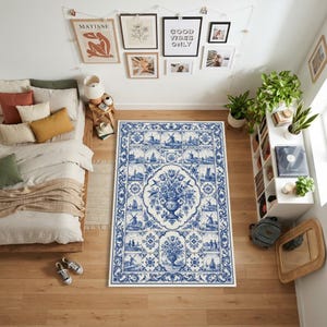 May include: A rectangular area rug featuring a blue and white pattern inspired by traditional delftware tiles. The design includes a central floral vase motif surrounded by smaller vignettes of windmills, sailboats, and figures in a grid layout.