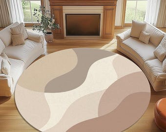 May include: A circular rug with an abstract pattern in beige, cream, and brown tones. The rug's design features flowing, curved shapes. It is placed on a wooden floor, and is a decorative element for a living room. The rug's diameter is approximately 200 cm.