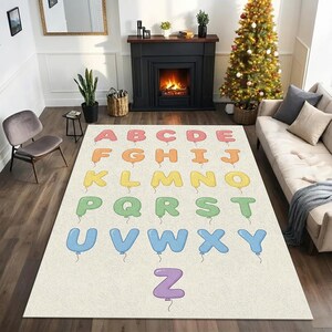 Könnte beinhalten: Ein rechteckiger Teppich mit dem Alphabet in bunten Ballonbuchstaben. Die Buchstaben sind in Regenbogenfarben gehalten, wobei jeder Buchstabe wie ein Ballon aussieht. Der Teppich hat einen hellbeigen Hintergrund.