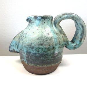 May include: A set of three ceramic mugs with a speckled, matte finish. The mugs are in shades of cream, light gray, and dark gray. Each mug has a simple, minimalist design, perfect for coffee or tea.