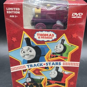 Könnte beinhalten: Ein limitiertes Thomas & Friends Track Stars DVD-Set in einer roten Schachtel mit einer violetten Spielzeugeisenbahn. Die Verpackung zeigt Illustrationen verschiedener Zugfiguren in gelben Sternformen und enthält den Text Limited Edition.
