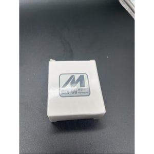 May include: A white rectangular box with a blue and white logo. The logo features the letter "M" and the text "DEV-56 HIGH TORQUE". The box is on a dark surface.