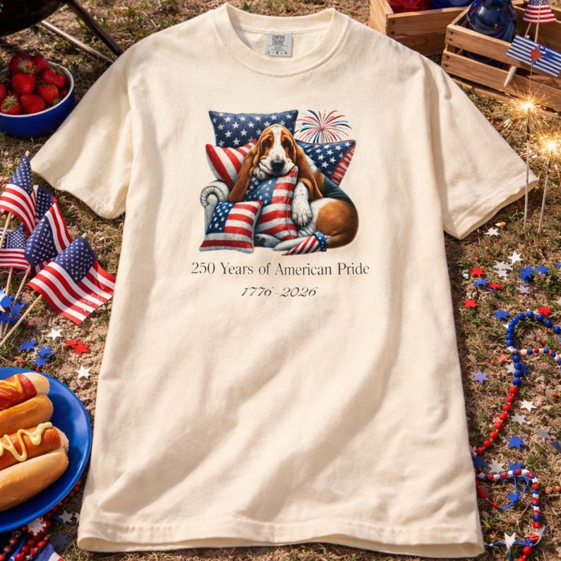 America 250 dog shirt cream ivory color styled outdoors with hot dogs flags and summer Independence Day decor.