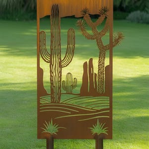 May include: A rectangular, rusty-brown metal garden art piece featuring a desert landscape scene. The design includes cut-out silhouettes of cacti, a Joshua tree, and other desert plants. The art piece is supported by two posts and is set against a green lawn.
