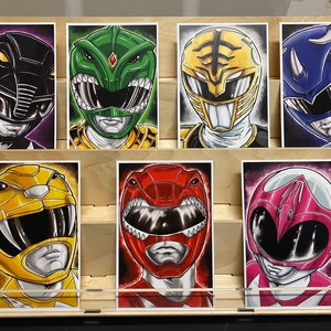 May include: Six illustrated cards featuring the Power Rangers characters. Each card features a different ranger in their signature colour and helmet. The rangers are: Black, Green, Yellow, Red, Pink, and Blue.
