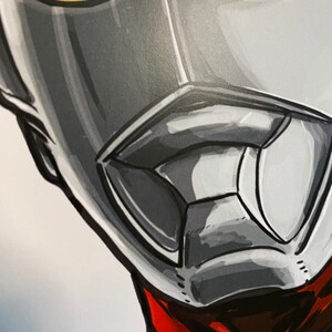 May include: Close-up of a silver and gray superhero mask with yellow eyes. The mask has a red and black scarf around the neck.