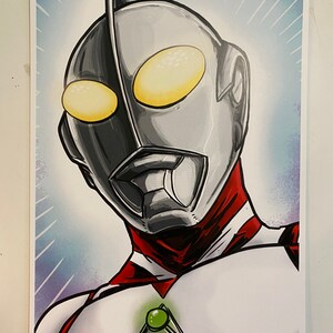May include: A digital illustration of a superhero with a silver and red suit. The superhero has a large, silver head with a pointed crest and yellow eyes. The superhero is wearing a red collar and a green gem on their chest.