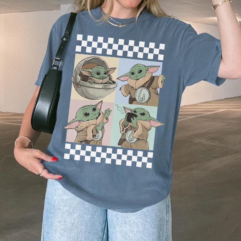 Pode incluir: Camiseta azul com um gr&aacute;fico de quatro pain&eacute;is de Grogu de The Mandalorian. Os pain&eacute;is mostram Grogu em diferentes poses, rodeado por um padr&atilde;o xadrez preto e branco. A camiseta &eacute; de estilo casual.