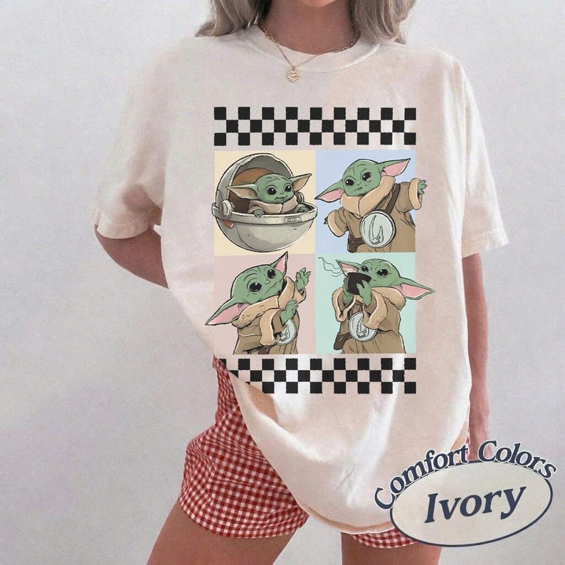 Pode incluir: Camiseta cor marfim com um gr&aacute;fico de quatro pain&eacute;is de Grogu de The Mandalorian. Cada painel mostra Grogu em poses diferentes. A camisa tem um padr&atilde;o xadrez preto e branco na parte superior e inferior.