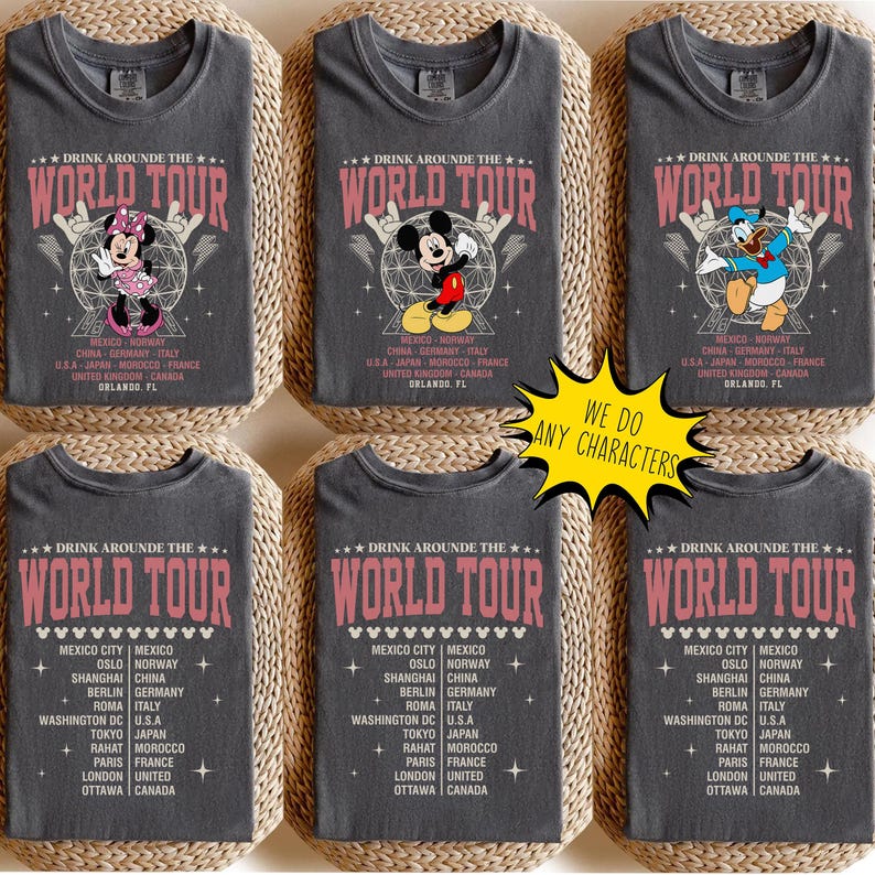 May include: Six gray t-shirts with a "World Tour" graphic in pink, featuring Disney characters like Minnie Mouse, Mickey Mouse, and Donald Duck. The shirts include a list of cities. A yellow sign says "We do any characters."