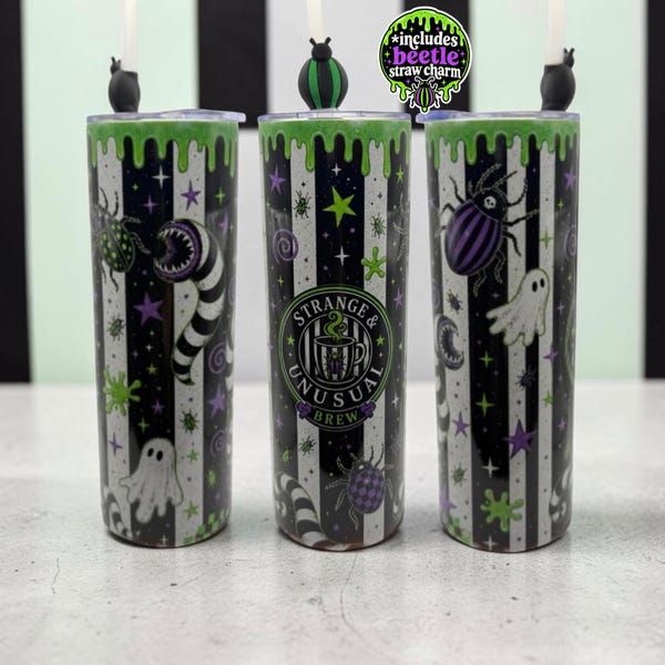 May include: Three cylindrical tumblers featuring a black and white vertical striped pattern with green slime drips at the top. The design includes ghosts, beetles, and stars, with a central logo reading Strange & Unusual Brew. Each lid has a beetle straw charm.
