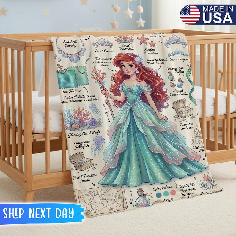 May include: A baby blanket featuring a detailed illustration of a mermaid in a teal gown, surrounded by marine-themed graphics. The blanket includes text such as "Seashell Jewelry" and "Pearl Crowns". The blanket is made in the USA.