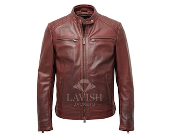 Puede incluir: Chaqueta de cuero burdeos con cuello alzado y cierre de cremallera frontal. La chaqueta tiene dos bolsillos en el pecho con cremallera y dos bolsillos inferiores con cremallera. Los hombros tienen detalles acolchados. El texto "LAVISH JACKETS" es visible.