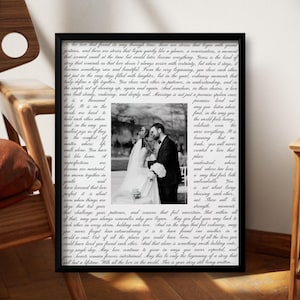May include: A framed black and white wedding photo. The photo is centered within a black frame, surrounded by a printed script. The photo shows a couple embracing. The text around the photo is a poem about love and marriage.