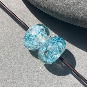 Pair of light turquoise transparent glass doughnut beads with inner bubbles