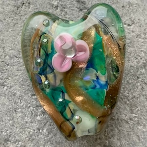 Delicate green heart lampwork glass focal bead with goldstone detail and three-petalled flower
